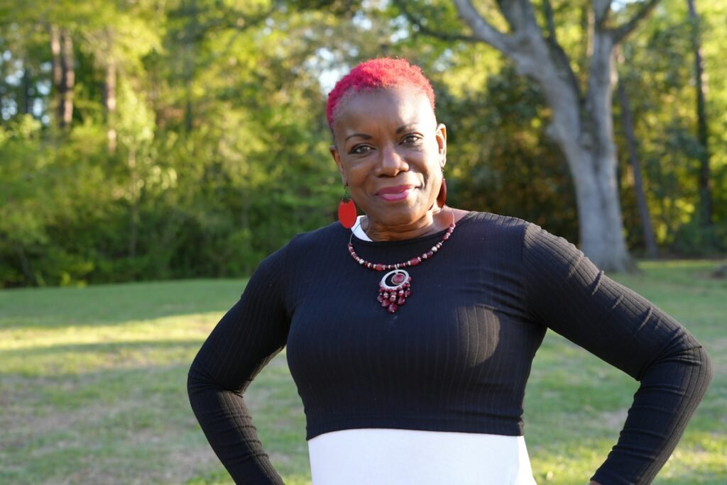 a woman in a black and white dress standing in a field